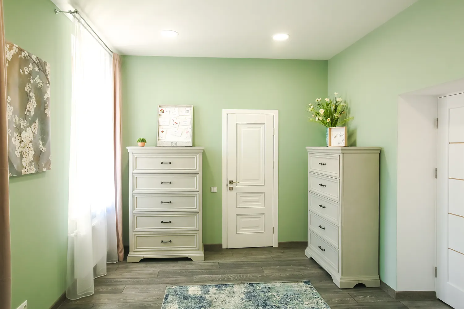 A bedroom with dressers and fresh flowers