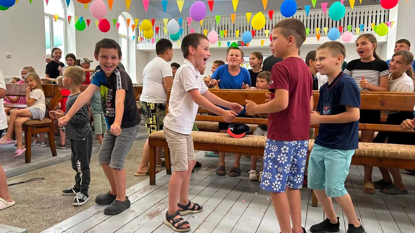 Children playing games together in the camp hall
