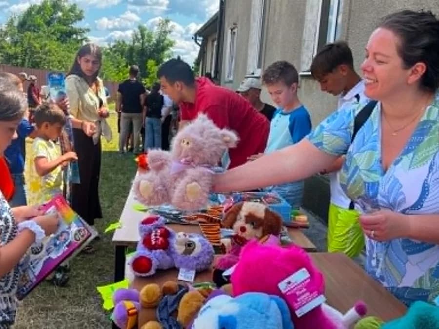 Children choosing gifts from a table of stuffed toys